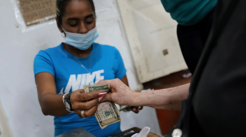 Mujer pagando con dólares en Venezuela