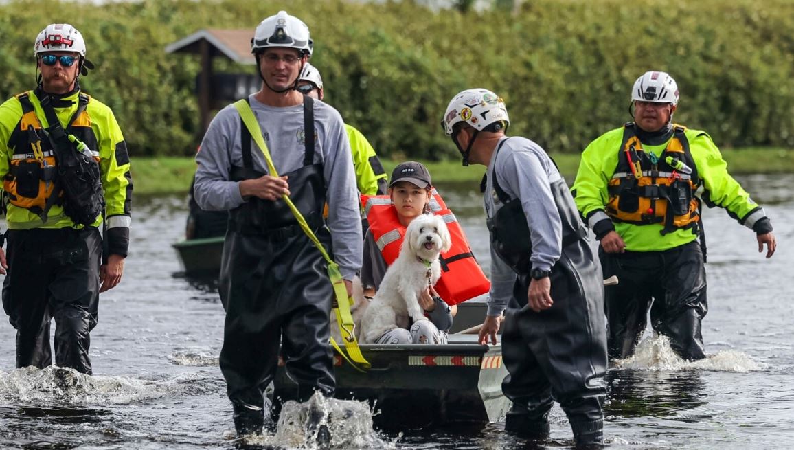 Amy Bishop es evacuada de su casa por bomberos y rescatistas mientras las aguas suben en su vecindario después de que el huracán Milton provocara la inundación del río Anclote, el 11 de octubre de 2024, en New Port Richey, Florida.