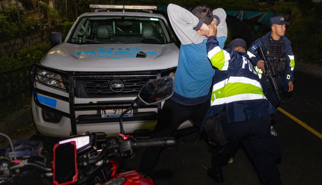 Foto divulgada por la Oficina de Prensa de la Presidencia de El Salvador muestra a un agente de la policía revisando a un hombre durante una acción contra pandilleros en San Marcos, El Salvador, el 28 de octubre de 2024.