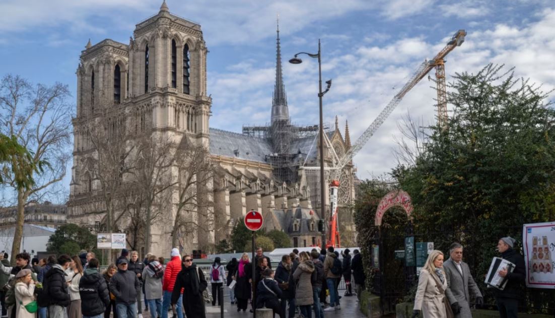 Peatones caminan cerca de la emblemática catedral de Notre Dame de Francia, horas antes de reabrir formalmente sus puertas por primera vez desde que un devastador incendio casi destruyó el monumento de 861 años de antigüedad en 2019, el sábado 7 de diciembre de 2024, en París.