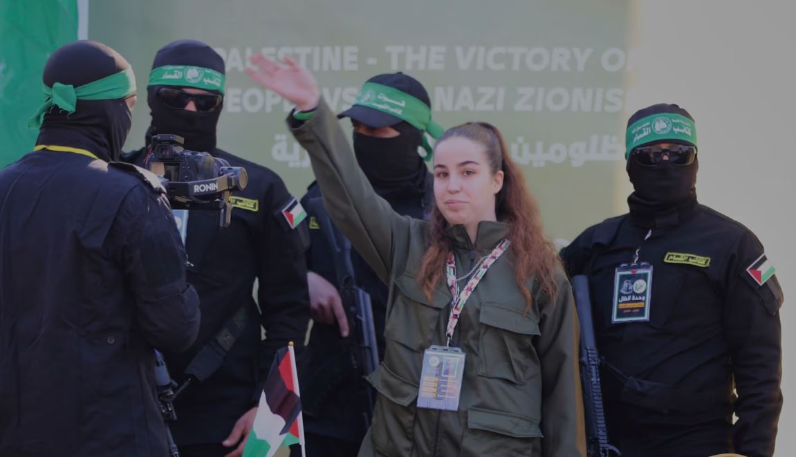 La soldado israelí Agam Berger saluda a la multitud junto a militantes enmascarados de la Jihad Islámica mientras es entregada a la Cruz Roja en el campo de refugiados de Jabalia en la ciudad de Gaza, el 30 de enero de 2025.