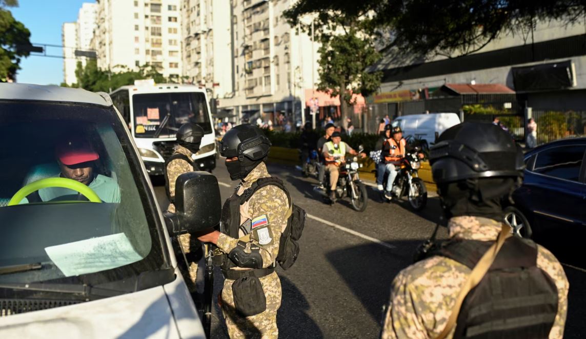 Un oficial de la DGCIM pide los documentos de un conductor en un puesto de control, días antes de que el presidente Nicolás Maduro comience oficialmente su tercer mandato en el cargo, en Caracas, Venezuela, el 8 de enero de 2025. REUTERS/Maxwell Briceno