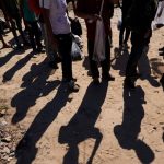 Migrantes esperan ser procesados ​​por la Oficina de Aduanas y Patrulla Fronteriza de Estados Unidos después de cruzar el Río Grande e ingresar a Estados Unidos desde México.