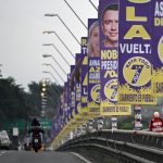Los vehículos pasan por un puente decorado con propaganda electoral del presidente y candidato presidencial de Ecuador, Daniel Noboa, en Guayaquil, Ecuador, el 7 de febrero de 2025.