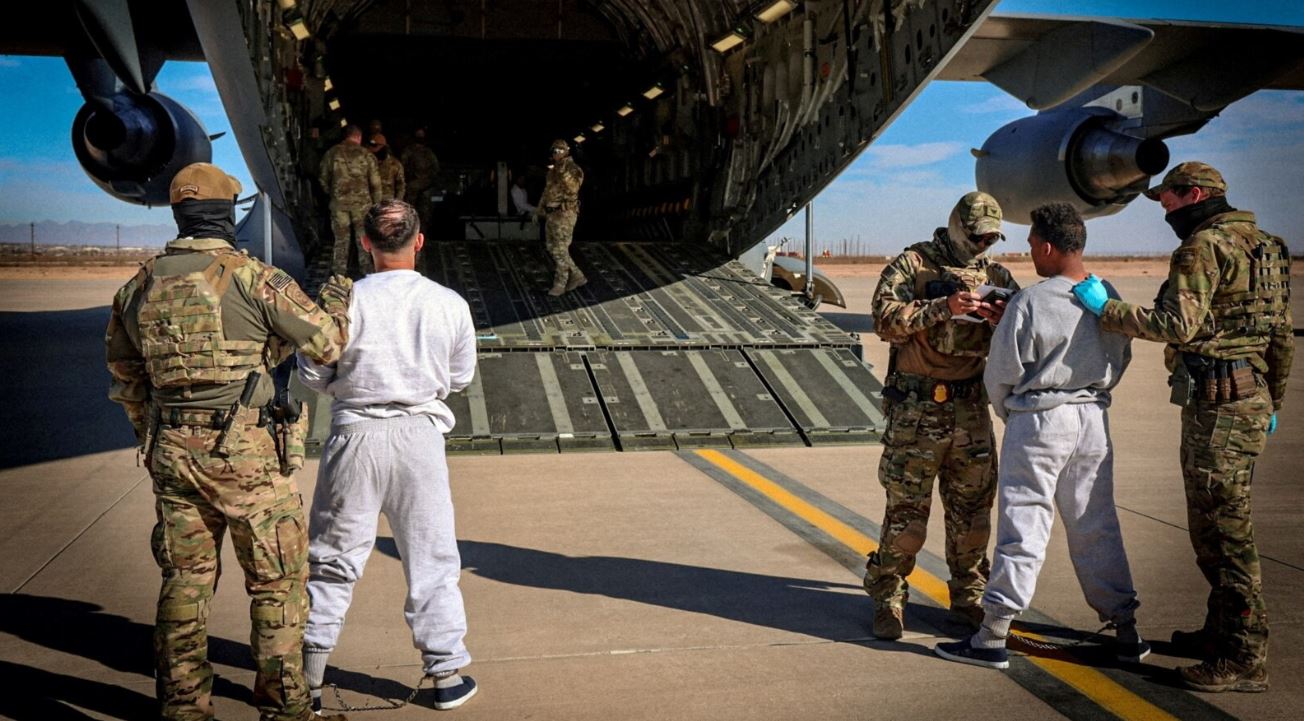 ARCHIVO - Un avión militar estadounidense revisa a migrantes antes de trasladarlos a la cárcel de la Bahía de Guantánamo desde una locación no especificada, el 4 de febrero de 2025.