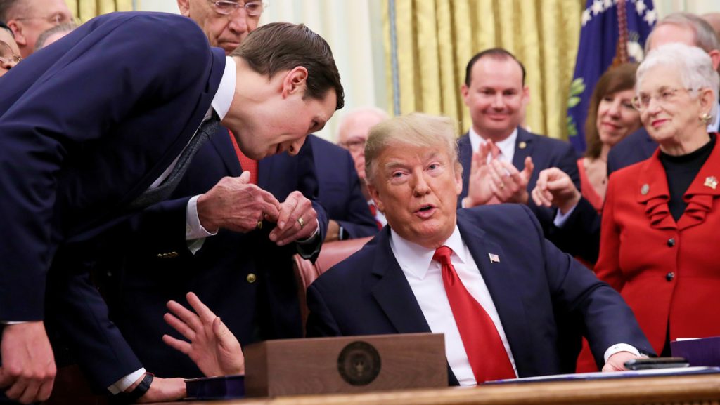 El por entoncesasesor principal del presidente Jared Kushner se inclina para hablar con el presidente de Estados Unidos, Donald Trump en el Despacho Oval, el 21 de diciembre de 2018.