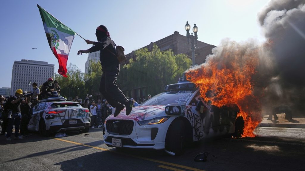 Un manifestante salta de un taxi en llamas en el centro de Los Ángeles (California, EE.UU.), el 8 de junio de 2025.