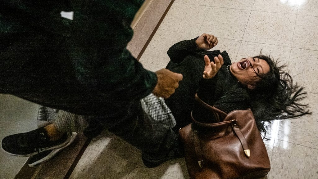 Un agente federal empuja al suelo a la esposa de un migrante detenido el 25 de septiembre de 2025 en la ciudad de Nueva York.