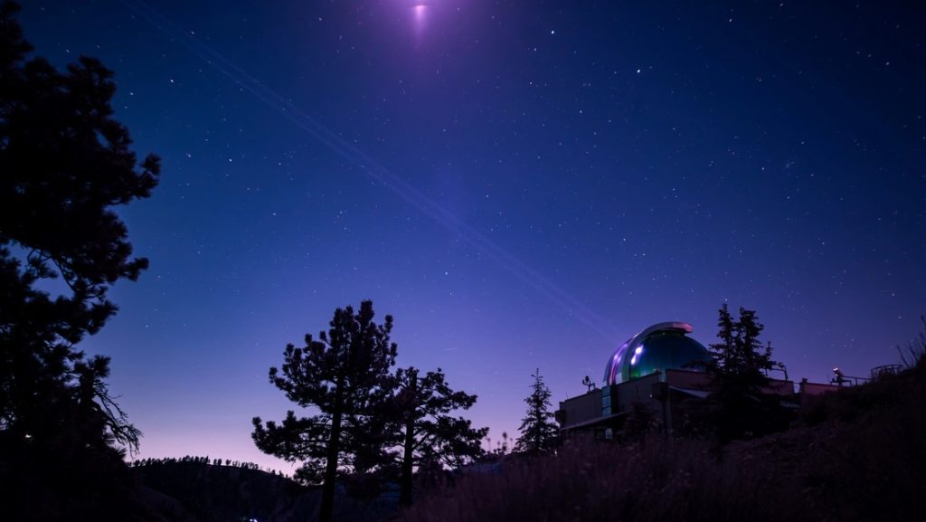 En esta imagen infrarroja, el Laboratorio de Comunicaciones Ópticas del JPL en Table Mountain, California, envía su baliza de ocho láseres al transceptor láser de la nave Psyche de la NASA en el espacio profundo.