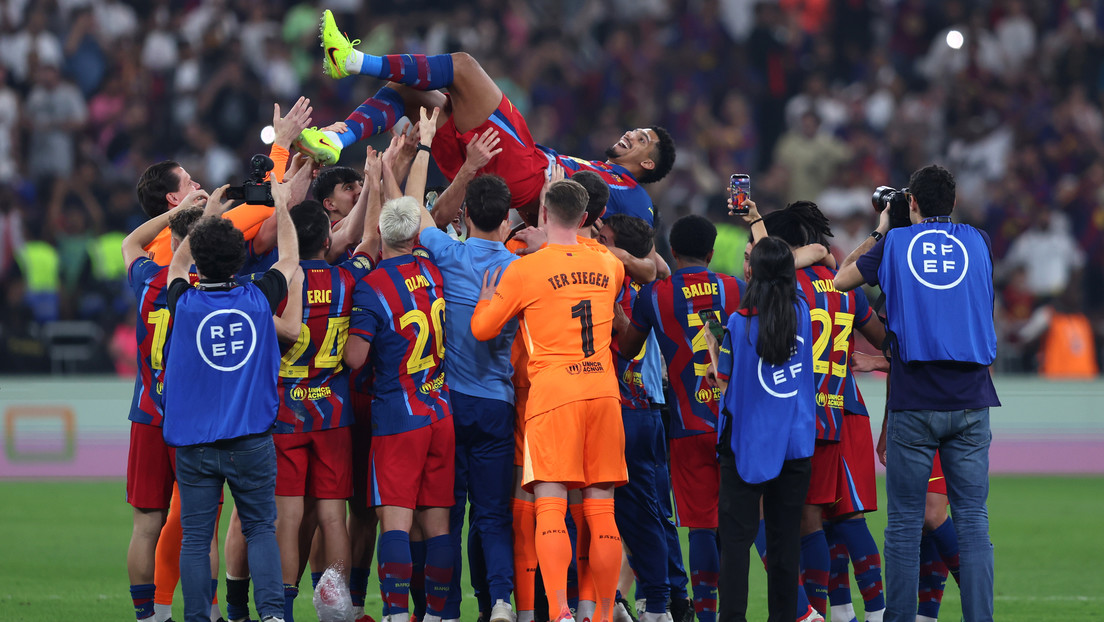 Los jugadores del F.C. Barcelona lanzan al aire a Ronald Araujo tras la victoria de su equipo en la final de la Supercopa de España en el estadio King Abdullah Sports City Hall el 11 de enero de 2026 en Jeddah, Arabia Saudita.